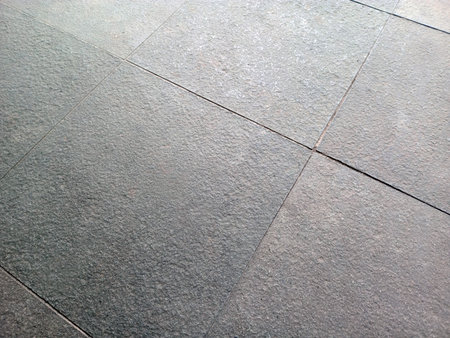 Close up of textured gray stone tiles arranged in a grid patternの写真素材