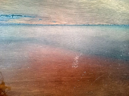 A close up view of a wooden surface showing natural grain patterns and textures. The wood has a warm tone with subtle variations in color and sheen, suggesting age and character.の写真素材