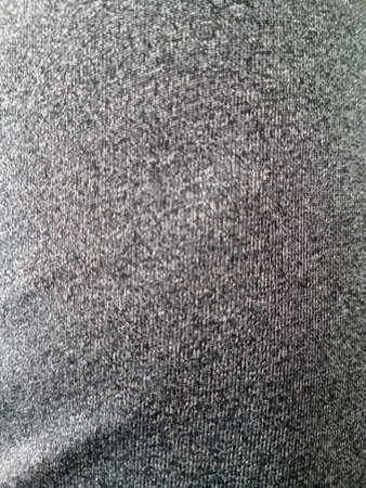 Close up texture of a dark gray fabric, showcasing a soft and smooth surface with a subtle pattern.の写真素材