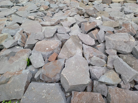 Close up of a pile of gray and brown rocks, varying in size and shape.