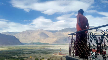 A monk enjoys the view. At a monastery in Nubra Valley, Ladakh, Indiaの写真素材