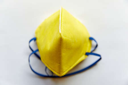 Yellow N95 Mask on a white background (isolated)- Leak proof, skin friendly, has Micro fine fibers and with electrostatic charge gives max filtering efficiency filters >95% non oil based particlesの写真素材