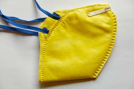 Yellow N95 Mask on a white background (isolated)- Leak proof, skin friendly, has Micro fine fibers and with electrostatic charge gives max filtering efficiency filters >95% non oil based particlesの写真素材