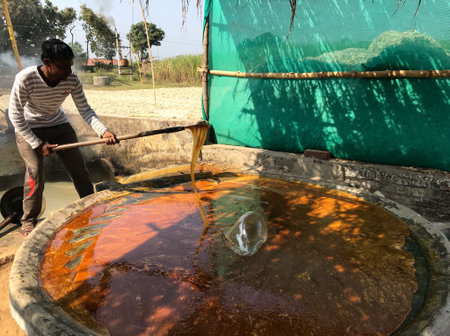 Narsinghpur, Madhya Pradesh/India : November 16, 2019 - A man making jaggery from sugarcane juiceのeditorial素材