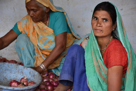 Karakbel, Madhya Pradesh/India : June 4, 2020 - Indian women separating rotten onions from the onion stockのeditorial素材