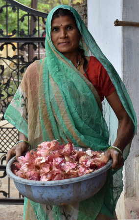 Karakbel, Madhya Pradesh/India : June 4, 2020 - Indian woman holding a tub of onion peelsのeditorial素材