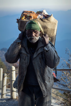 Portrait of an old man carrying luggage