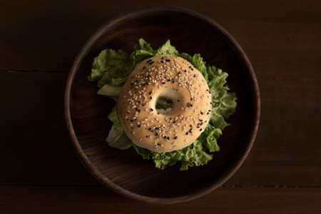 Food Photograph of a Bagel Burger on a wooden backgroundの写真素材