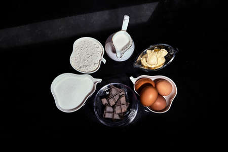 Photography of ingredients needed to make homemade profiteroles. milk, eggs, butter, chocolate, sugar, flour. Ingredients for desserts.の写真素材