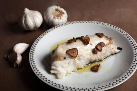 Hake head fillet baked with garlic. Homemade food concept