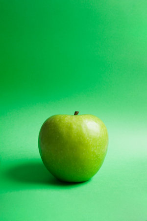 granny smith's green apple on green backgroundの写真素材