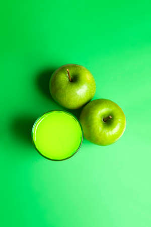 Top view of apple juice with apples on green background. Healthy drink concept.の写真素材