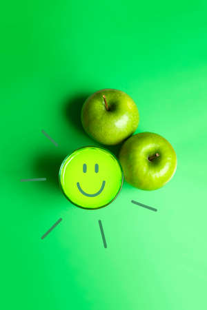 Sun with a smile drawn on an apple juice to say good morning. Healthy breakfast concept.の写真素材