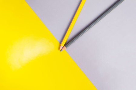 yellow and gray pencil on a background of the same inverted color. Concept geometric office or...