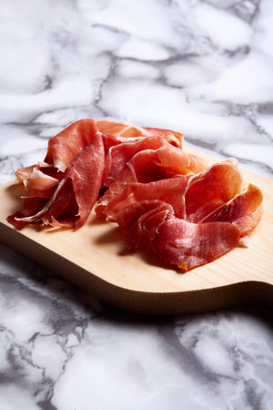 Iberian Serrano Ham tapa on cutting board with marble bottomの写真素材