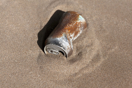 rusty can buried in the desert sand. Environment, recycling, garbage concept