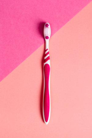 Pink toothbrush on pink background. Copy space.