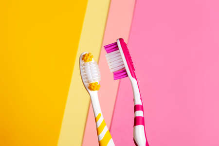 toothbrushes in two colors, yellow and pink. 2 color background. Copy space.の写真素材