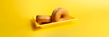 Glazed donuts on yellow backgroundの写真素材