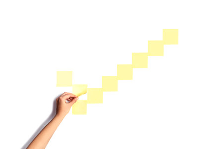 checkmark made with empty sticky notes with a hand holding one of them. To do concept.の写真素材