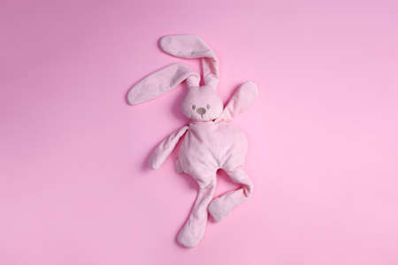top view of cute pink plush rabbit dancing on pink background with copy spaceの写真素材