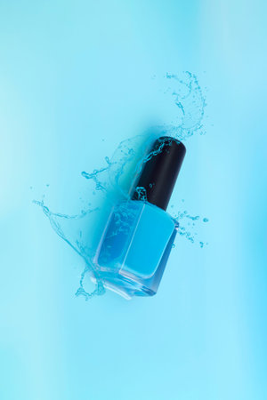Blue nail polish splashing on a background of the same color. Aesthetics concept.の写真素材