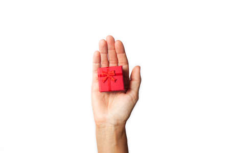 woman hand handing over a red gift box on white backgroundの写真素材