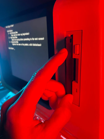 hand putting floppy disk into floppy drive