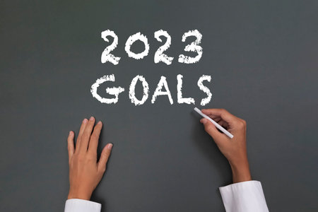 woman hands writing "2023 goals" on blackboardの写真素材