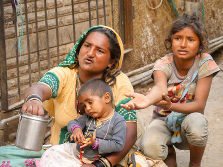 Pushkar, Rajasthan / India - November 5, 2019 : Indian Young Woman Beggar with her Child begging in...