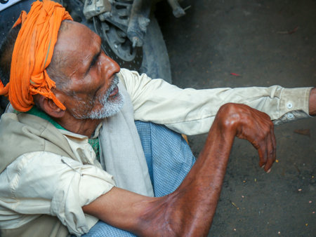 Pushkar, Rajasthan / India - November 5, 2019 : Old Aged poor man, his hand twisted sitting in street outside temple for helpのeditorial素材