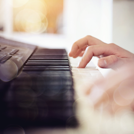 Blurred background with a synthesizer and the musician's hand.の写真素材