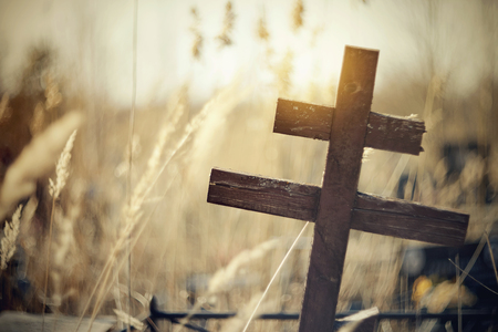 The old wooden lop-sided cross at the cemetery.の写真素材