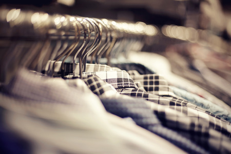 Clothes on hangers in shop for sale. Blur background.の写真素材