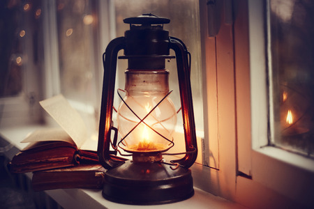 Kerosene lamp and old books on the windowsill.