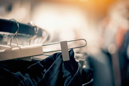 Shopping in store. Clothes on hangers in shop for sale. Blur background. Fashionable clothes in a boutique. Various clothing on market.の写真素材