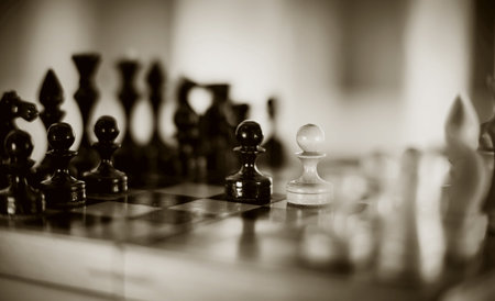 Two chess pieces are pawns: black and white. Wooden chess pieces on the chessboard. Intellectual...