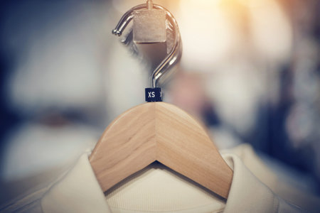 Hangers with clothing size xs close-up. Shopping in store. Clothes on hangers in shop for sale. Blur background. Fashionable clothes in a boutique. Various clothing on market.の写真素材