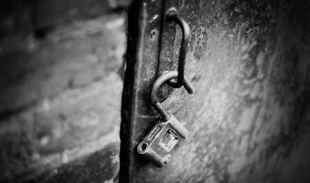 A metal open lock hangs on the door handle. Not color image.の写真素材