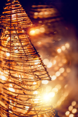 Decorative Christmas tree with a burning garland with the reflection of lights in the dark glass of the window. Christmas decoration at home.の写真素材