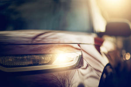 The car's headlight. Parked cars. Reflection of the building in the shiny surface of the car. Background with the side surface of the car.の写真素材