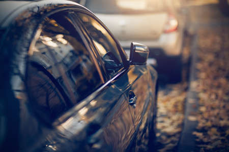 Parked cars. Reflection of the building in the shiny surface of the car. The window and door of the car. Background with the side surface of the car.の写真素材