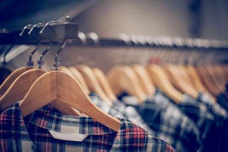Shirts on hangers. Shopping in store. Clothes on hangers in shop for sale. Blur background. Fashionable clothes in a boutique. Various clothing on market.の写真素材