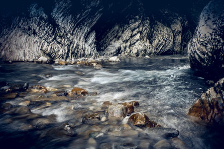 The rapid flow of the river with a rocky bottom. Background with water flowing over the stones.の写真素材