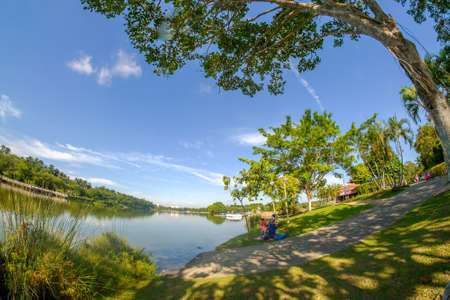 Putrajaya, Malaysia â September 24th, 2017 : Young girl with her young brotherS feeding carps in tropical pond at Wetland Putrajaya.のeditorial素材