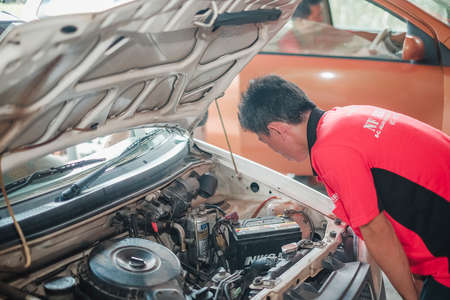 Segamat, Malaysia - November 11th , 2017 : Automobile air-conditioner servicing. Mechanic checking cooling system in car engine.のeditorial素材