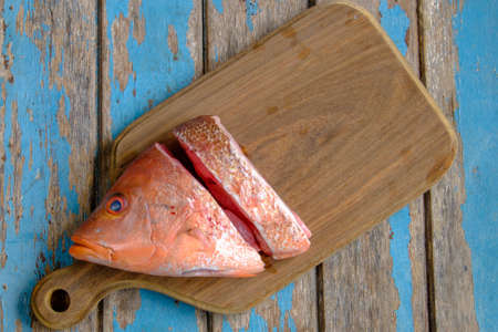 Fresh red snapper on wooden cutting board .の写真素材