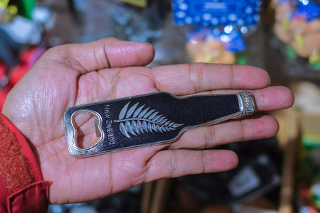 Christchurch, New Zealand â December 19th, 2017 : Man holding New Zealand bottle opener souvenir fridge magnet in DP Souvenir shop at Christchurch, New Zealand.のeditorial素材