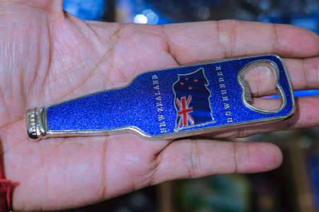 Christchurch, New Zealand â December 19th, 2017 : Man holding New Zealand bottle opener souvenir fridge magnet in DP Souvenir shop at Christchurch, New Zealand.のeditorial素材