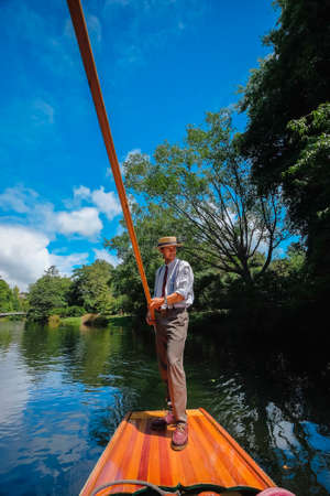 Christchurch, New Zealand â December 14th ,2017 :  Handsome boatman punting the boat for tourists to enjoy the river view on Christchurch Botanic Garden. One of Iconic Christchurch attraction.のeditorial素材